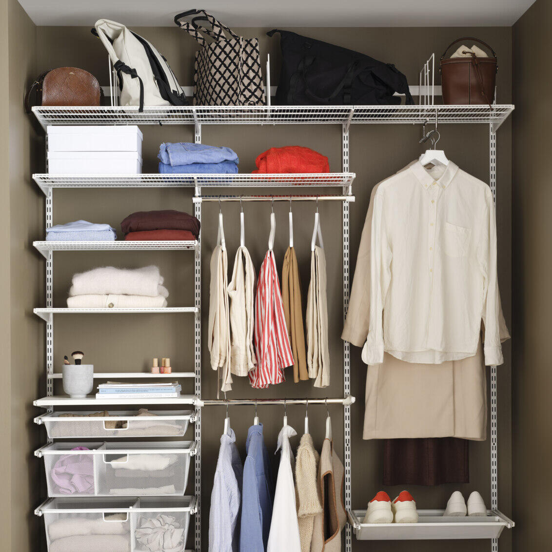 Offener Kleiderschrank von Elfa mit Drahtböden, ausziehbaren Netzschubladen, hängenden Kleider- und Schuhregalen.