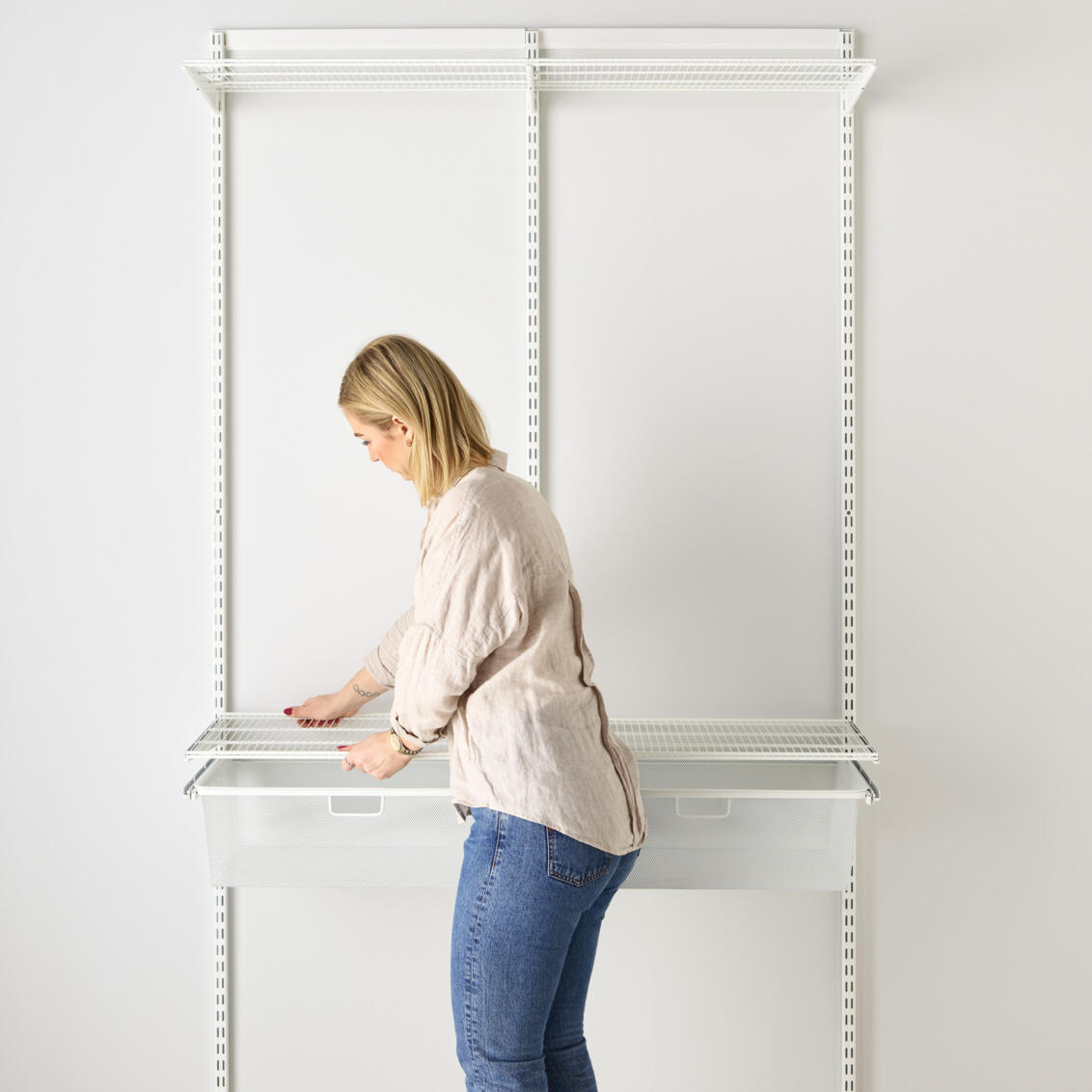 En kvinna visar hur man monterar en hylla.