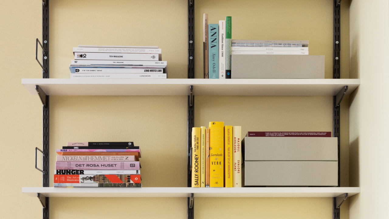 Regał Sparring Elfa z szynami ściennymi w kolorze szarym i z półkami z melaminy w kolorze białym.