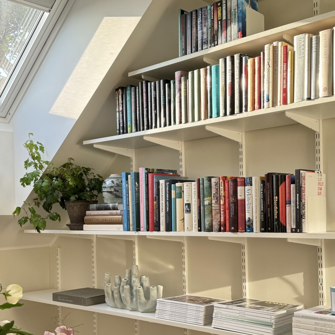 Sparring by Elfa -kirjahylly valkoisena vinokaton alla.