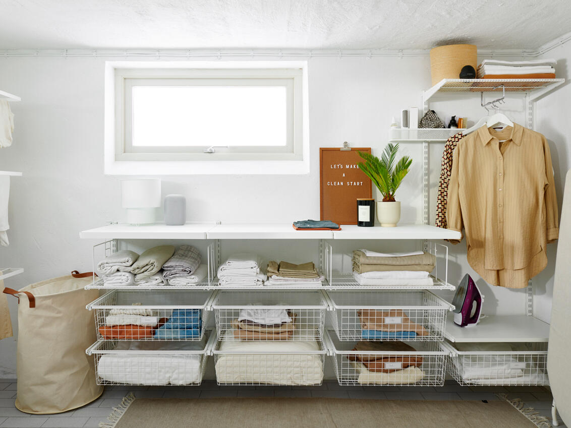 Laundry room with storage from Classic by Elfa in white with shelves where there are tablecloths and sheets.