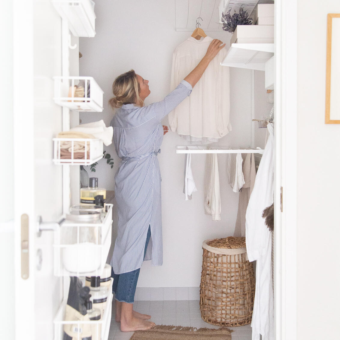 Niki hangs laundry in a laundry room with Classic by Elfa top-hung storage and door storage on the door.