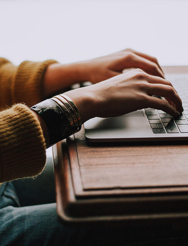 Osoba używająca laptopa do projektowania schowków kuchennych za pomocą narzędzia do planowania Elfa