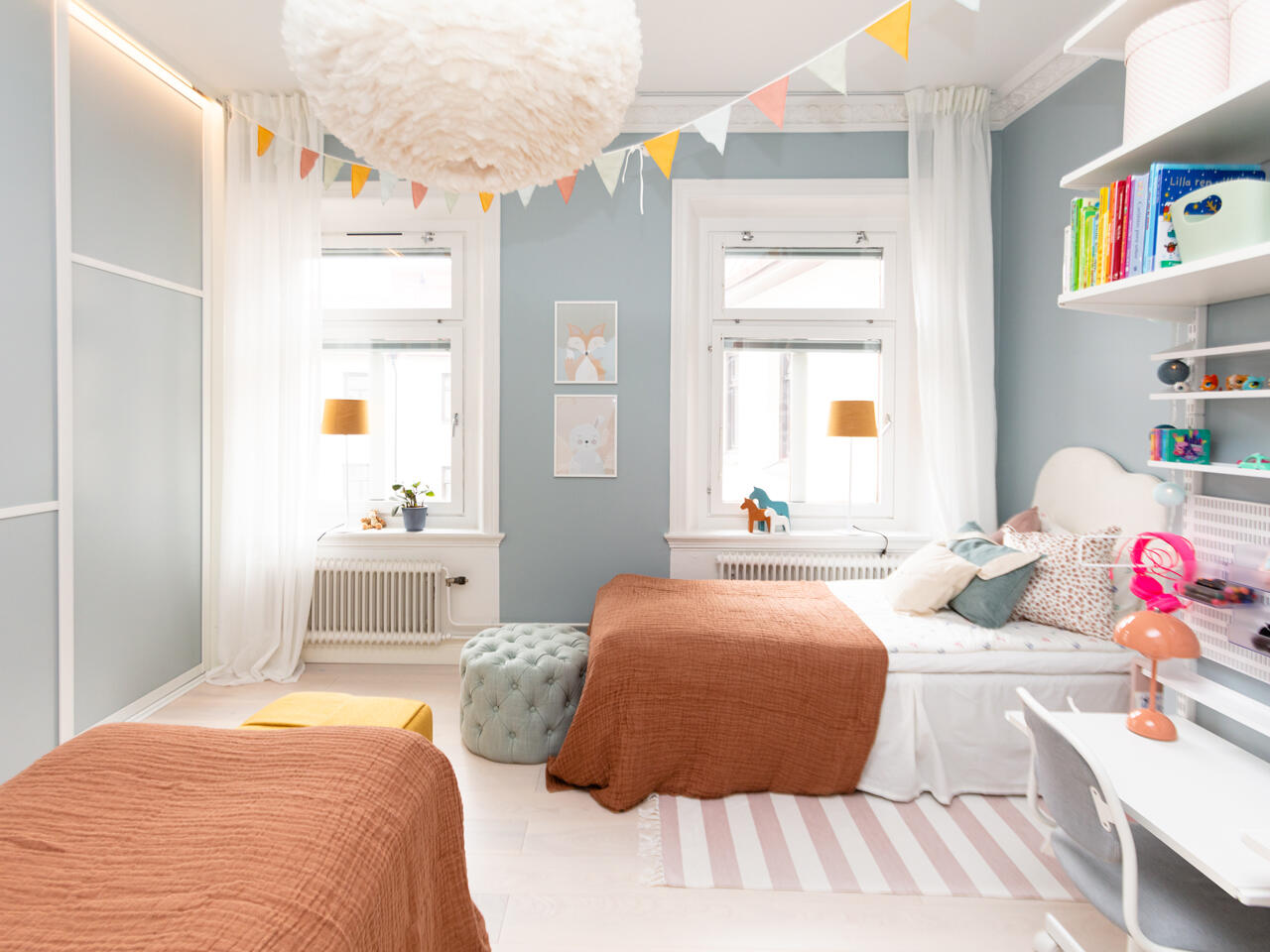 Posuvné dveře Elfa v dětských pokojích s knihovnami, barevnými vlaječkami a oranžovými přehozy
