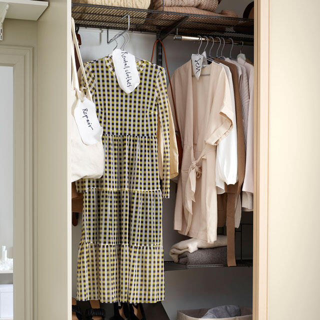 Almacenamiento de ropa en estantes y perchas.