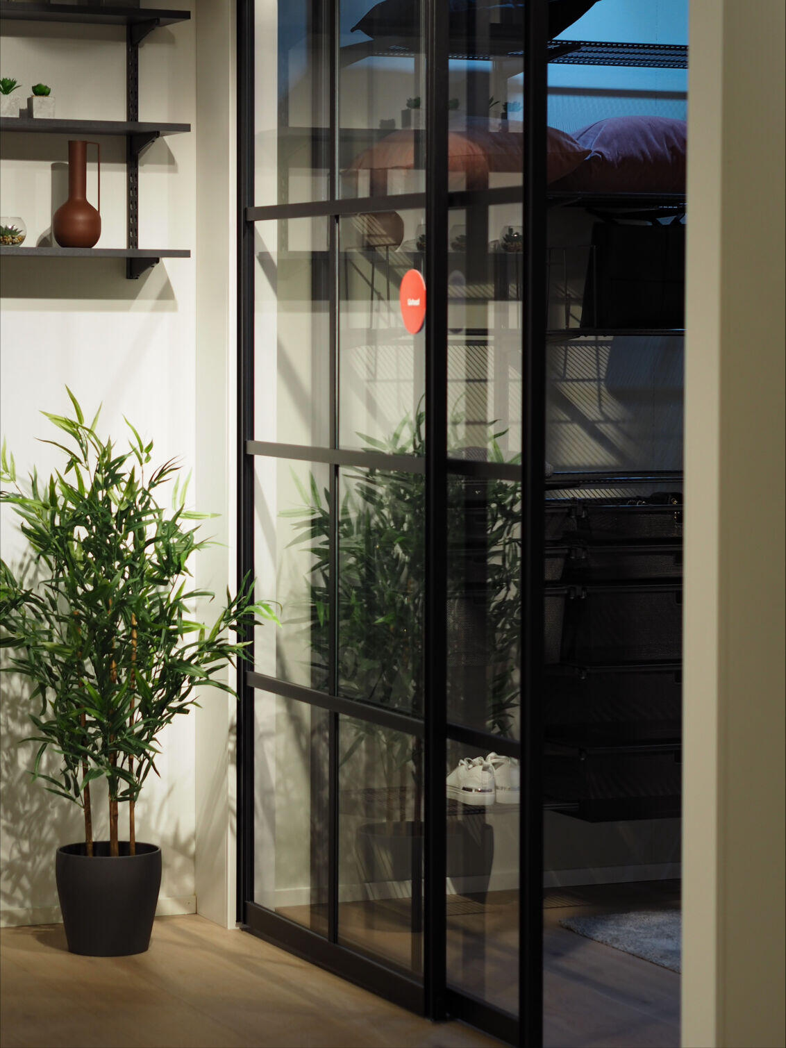 Mustat lasitäytteiset liukuovet käytävällä.