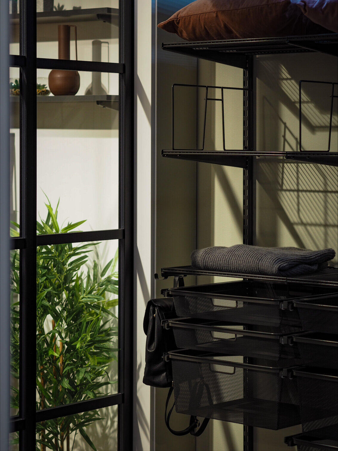 Mustat lasitäytteiset liukuovet käytävällä.