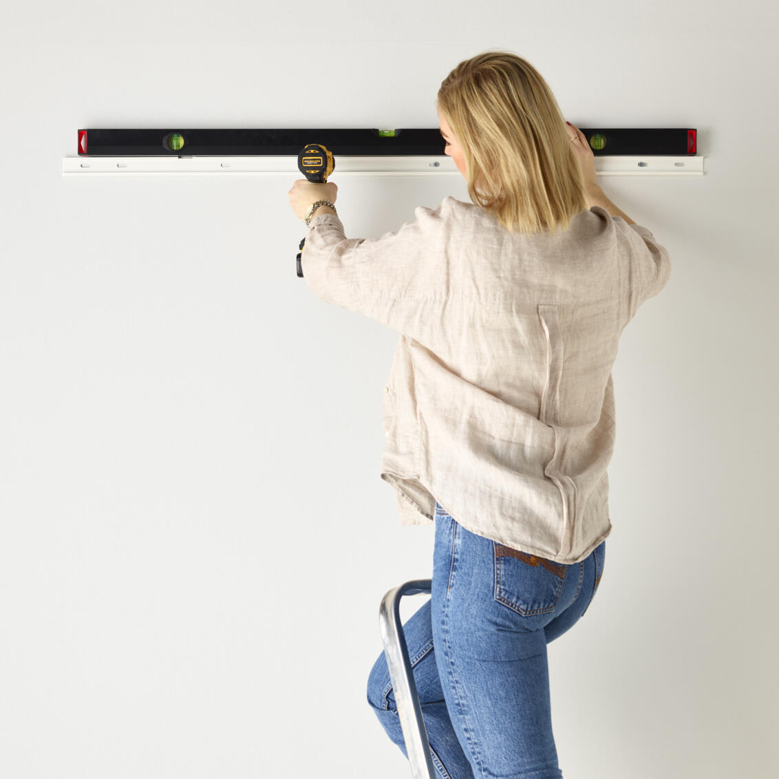 En kvinna visar hur man monterar en bärlist. 