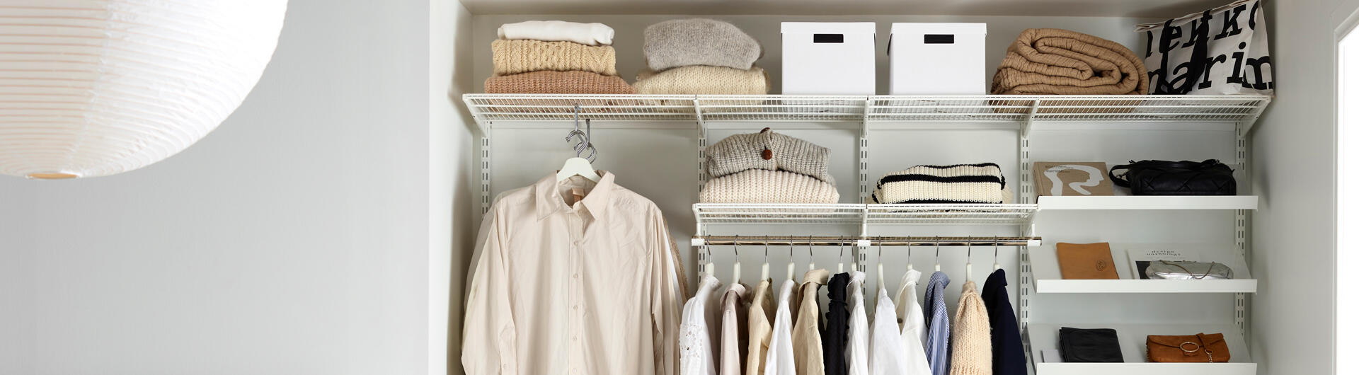 Åpen garderobeløsning på soverommet med hyller og garderobestang.