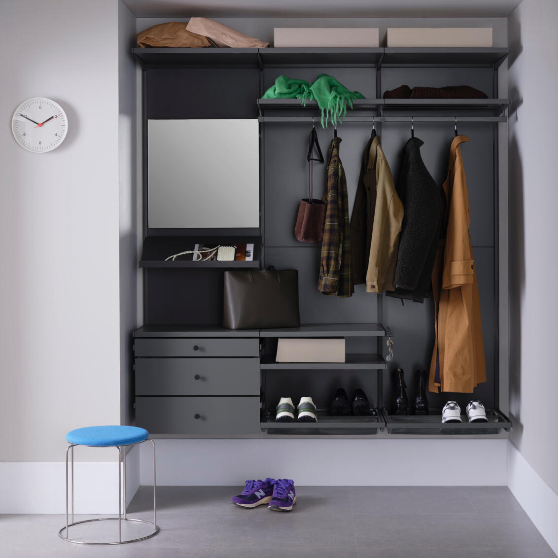 Gang med Décor+ garderobe fra Elfa i grått med hengende klær, uttrekkbare skuffer, speil og skohyller.