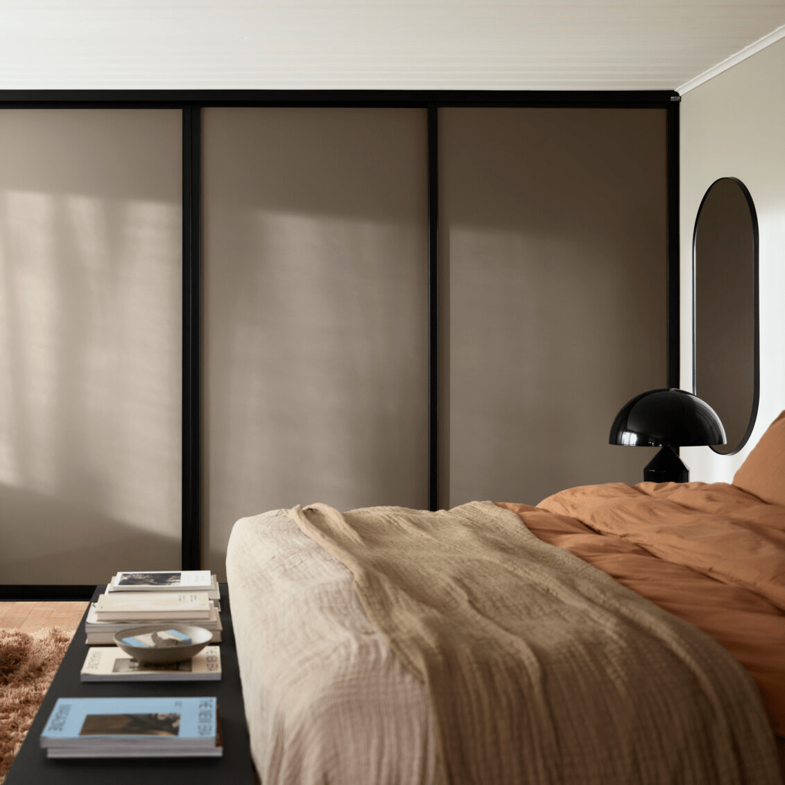 Makuuhuone, jossa on vaatekaappi Elfa-yhtiöltä liukuovilla Artic vaaleanruskeana.