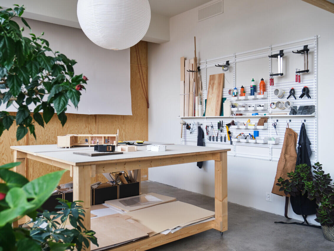 Elfa-skinner og oppbevaringsbrett integrert med sofistikert møbeldesign og brukt i røffe, industrielle miljøer.